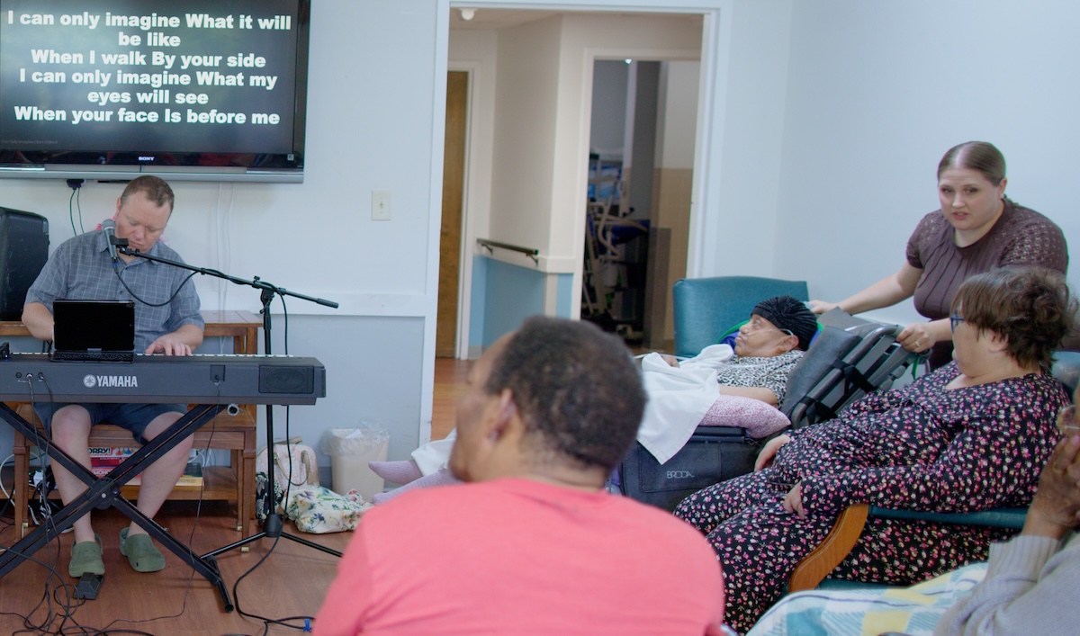 Helping another resident get settled while Jonathan leads worship